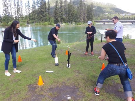 Group participate in teambuilding challenge by river