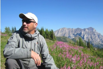 Guide rests near mounatin wildflowers at Fortress Mountain Resort