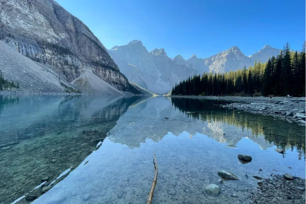 Turquoise Moraine Lake perfectly reflecting the Rocky Mountains on a calm summer day