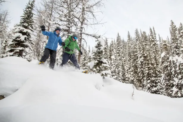 Winter fun with two people running on snowshoes at Sunshine Mountain
