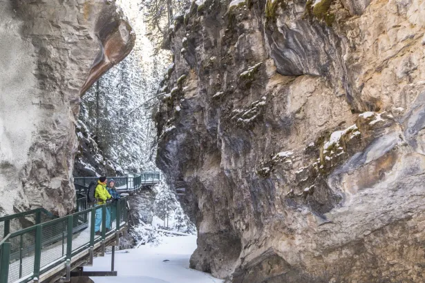 Visitors standing on canyon walkway looking up during Johnston Canyon icewalk