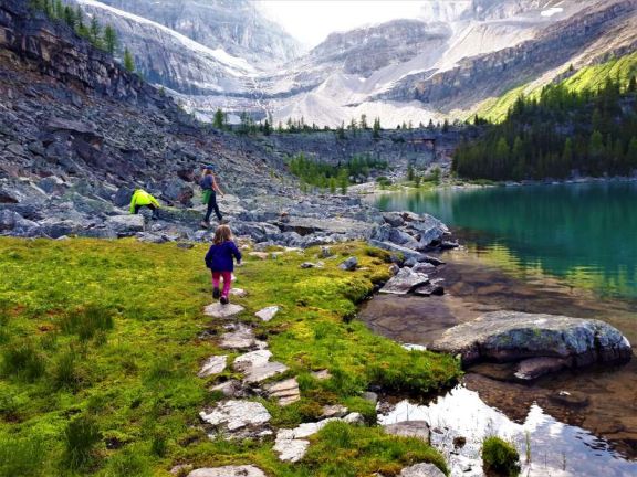 hiking along alpine lake with glacier in background