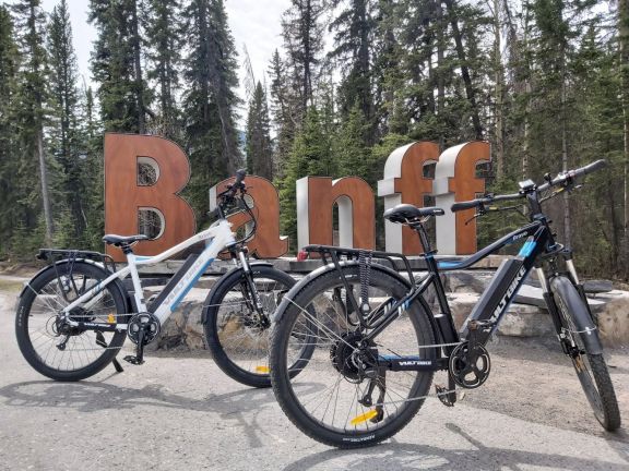 ebikes in front of Banff Welcome Sign